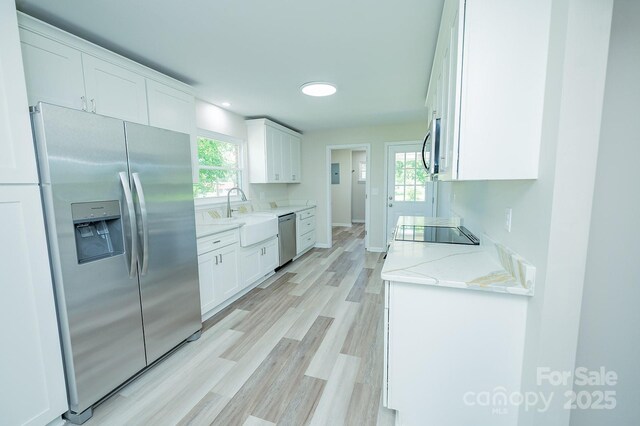 1696 Race Path Church Rd, Mooresboro, NC 28114 - kitchen with appliances with stainless steel finishes, white cabinets, light wood-style floors, and plenty of natural light