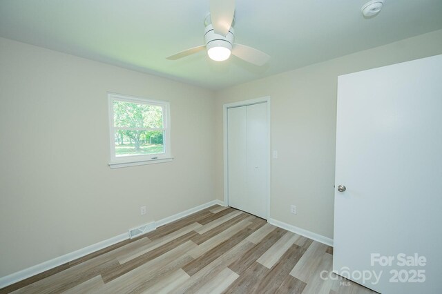 1696 Race Path Church Rd, Mooresboro, NC 28114 - unfurnished bedroom with light wood-type flooring, a closet, and ceiling fan