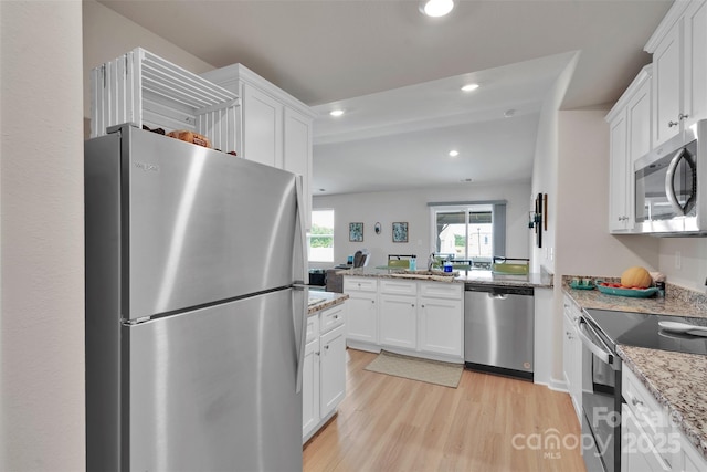 410 Apex Cir, Shelby, NC 28152 - kitchen with appliances with stainless steel finishes, light wood-style flooring, white cabinetry, recessed lighting, and light stone counters