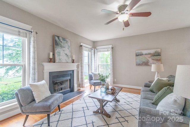 2619 Merion Hills Ct, Charlotte, NC 28269 - living room featuring a ceiling fan, a fireplace with raised hearth, and light wood-style flooring