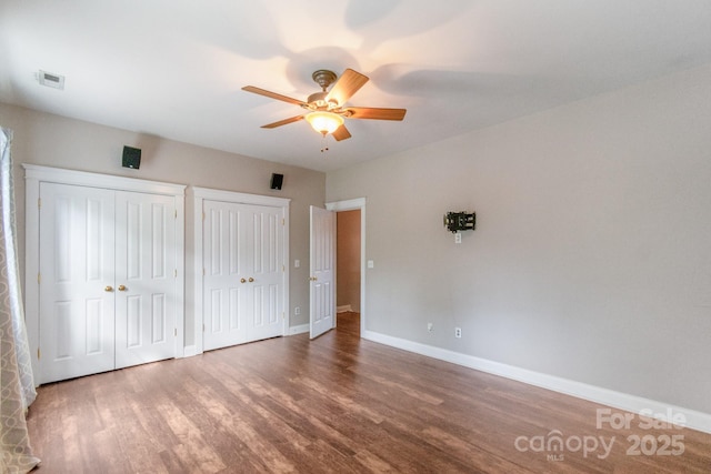 2619 Merion Hills Ct, Charlotte, NC 28269 - unfurnished bedroom with wood finished floors, two closets, and ceiling fan