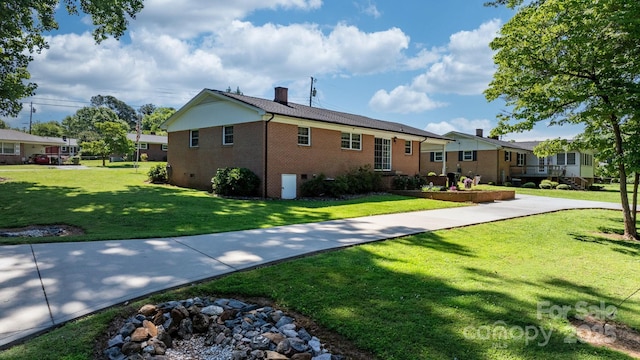 135 Burton Hills Cir, Gastonia, NC 28054 - view of front of house with brick siding, a front yard, and a chimney