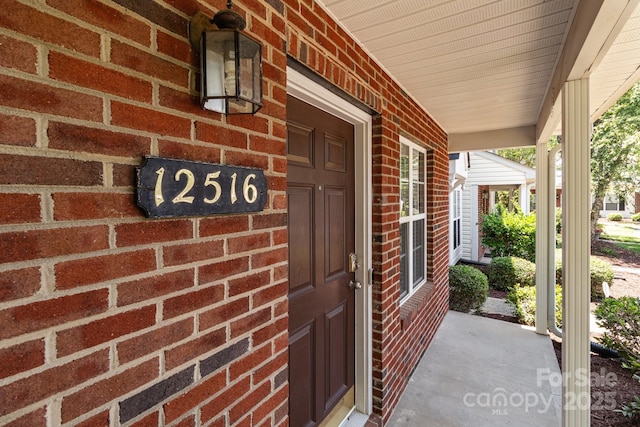 12516 Hennigan Place Ln, Charlotte, NC 28214 - doorway to property featuring covered porch and brick siding