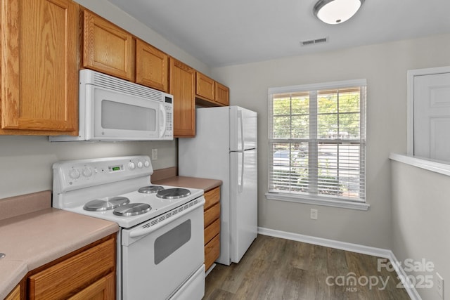12516 Hennigan Place Ln, Charlotte, NC 28214 - kitchen with white appliances, light countertops, dark wood-style flooring, and brown cabinetry