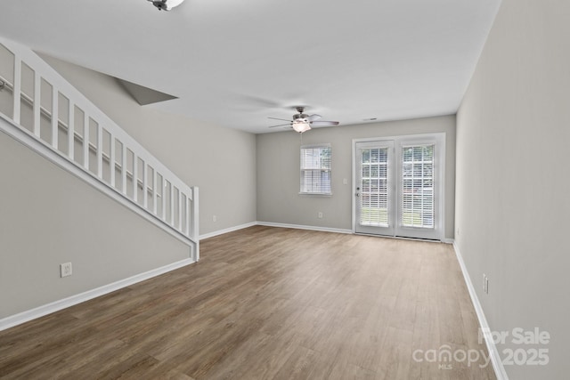 12516 Hennigan Place Ln, Charlotte, NC 28214 - unfurnished living room featuring a ceiling fan, wood finished floors, and stairs