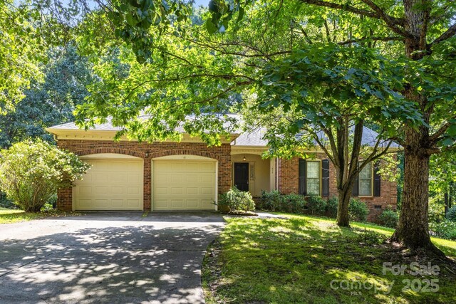 212 Foxfield Ln, Matthews, NC 28105 - view of front facade featuring an attached garage, concrete driveway, and brick siding