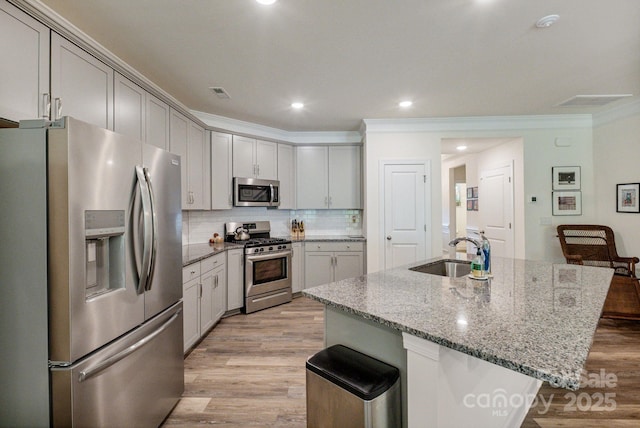 8042 Saluda Dr Unit 3, Charlotte, NC 28269 - kitchen featuring stainless steel appliances, light wood-style flooring, a kitchen bar, light stone counters, and backsplash