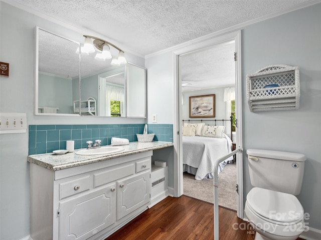 185 Indian Springs Rd, Clyde, NC 28721 - ensuite bathroom featuring a textured ceiling, wood finished floors, vanity, crown molding, and healthy amount of natural light