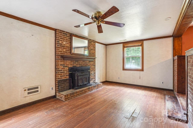 8706 Richardson King Rd, Waxhaw, NC 28173 - unfurnished living room featuring ceiling fan, wood-type flooring, crown molding, heating unit, and a wood stove