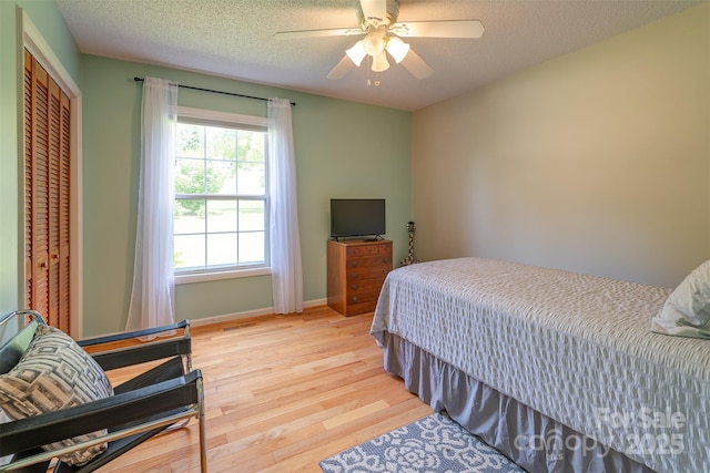 76 Woodland Hills Rd, Asheville, NC 28804 - bedroom with light wood finished floors, ceiling fan, a textured ceiling, and a closet
