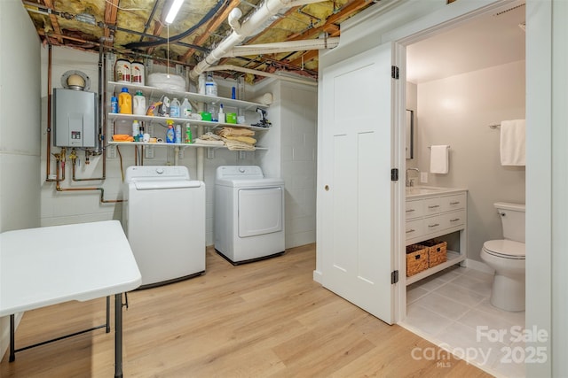 76 Woodland Hills Rd, Asheville, NC 28804 - laundry area featuring washing machine and dryer, light wood-type flooring, and tankless water heater