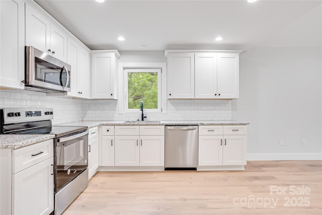 452 Duncan St, Spartanburg, SC 29306 - kitchen featuring stainless steel appliances, light wood-type flooring, white cabinetry, decorative backsplash, and recessed lighting