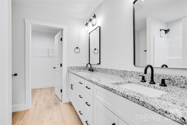 452 Duncan St, Spartanburg, SC 29306 - bathroom with double vanity, wood finished floors, a walk in closet, and a shower