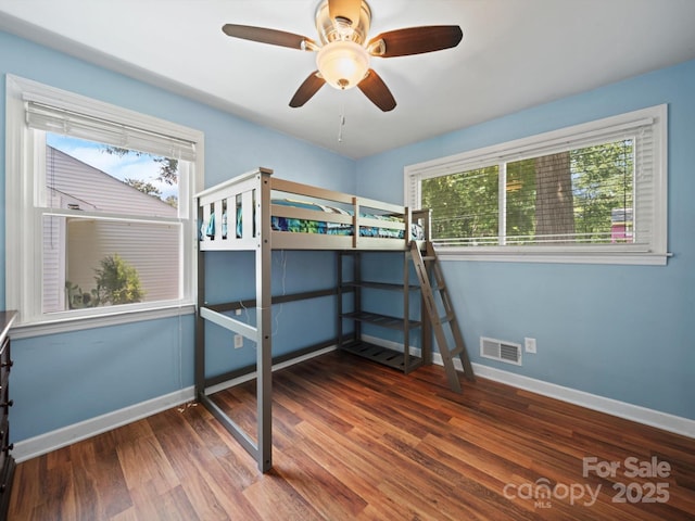 427 E 12th Ave, Gastonia, NC 28054 - unfurnished bedroom with multiple windows, wood finished floors, and a ceiling fan