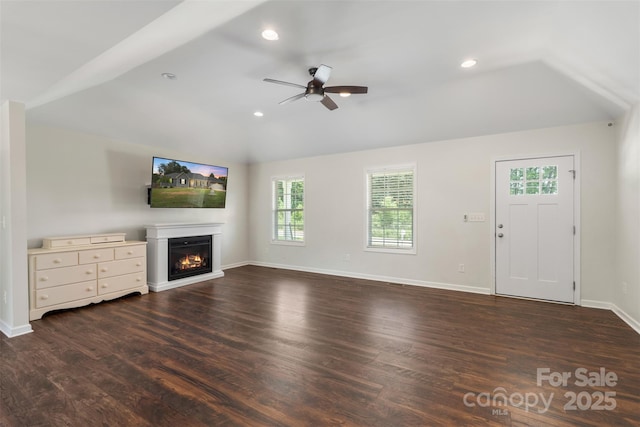 7627 Sarah Dr, Denver, NC 28037 - unfurnished living room featuring vaulted ceiling, a glass covered fireplace, plenty of natural light, a ceiling fan, and dark wood-style floors