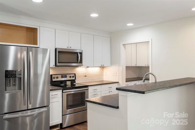 7627 Sarah Dr, Denver, NC 28037 - kitchen featuring stainless steel appliances, dark countertops, white cabinets, and recessed lighting