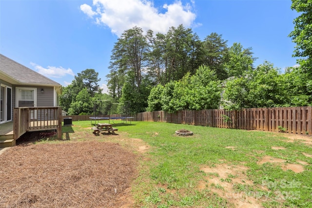 7627 Sarah Dr, Denver, NC 28037 - fenced backyard with a trampoline, a wooden deck, and an outdoor fire pit