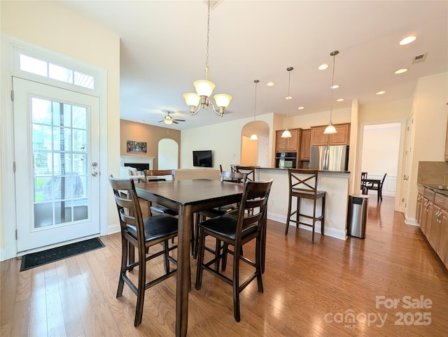 408 Presidio Dr, Rock Hill, SC 29732 - dining room with a fireplace, a chandelier, wood finished floors, a ceiling fan, and recessed lighting