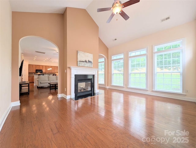 408 Presidio Dr, Rock Hill, SC 29732 - unfurnished living room with a fireplace with flush hearth, high vaulted ceiling, arched walkways, wood finished floors, and a ceiling fan