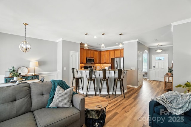 529 River Park Rd, Belmont, NC 28012 - living area featuring ornamental molding, light wood-style floors, a chandelier, arched walkways, and recessed lighting
