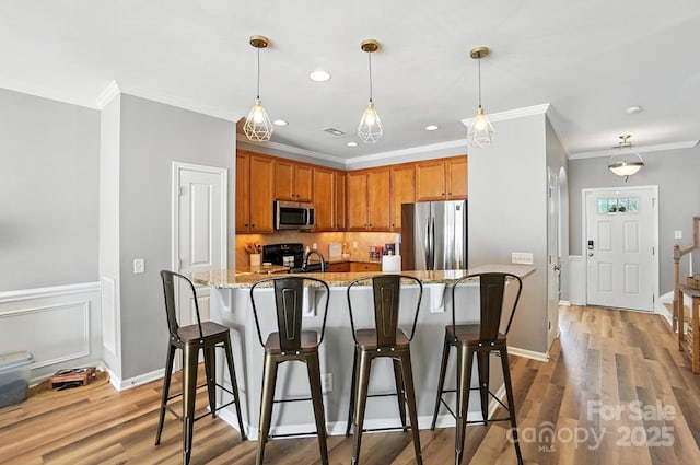 529 River Park Rd, Belmont, NC 28012 - kitchen featuring stainless steel appliances, a breakfast bar, light stone countertops, ornamental molding, and tasteful backsplash
