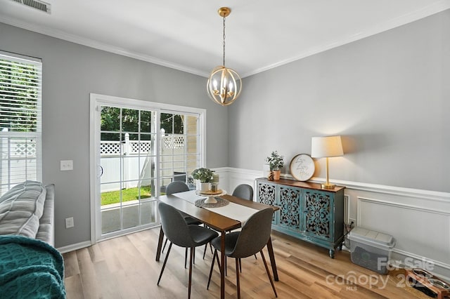 529 River Park Rd, Belmont, NC 28012 - dining area with a chandelier, healthy amount of natural light, light wood-style flooring, ornamental molding, and a wainscoted wall