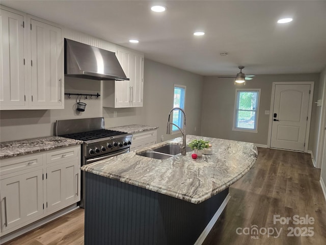 616 Laurel St, Albemarle, NC 28001 - kitchen with wall chimney range hood, stainless steel gas range, white cabinets, ceiling fan, and dark wood-type flooring
