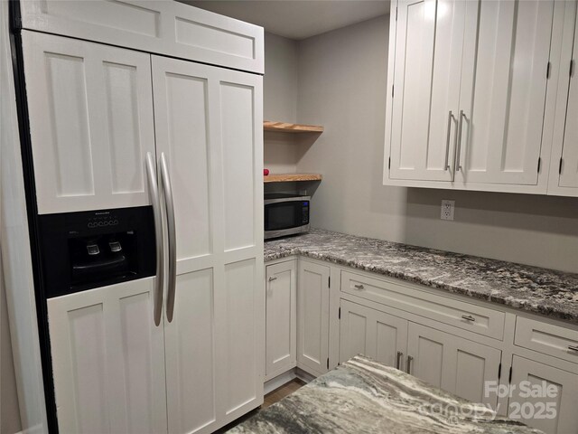 616 Laurel St, Albemarle, NC 28001 - kitchen with paneled fridge, stainless steel microwave, white cabinets, open shelves, and light stone counters
