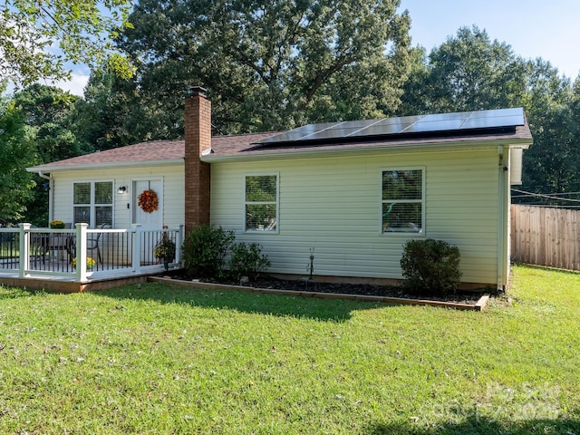327 Downing St, Troutman, NC 28166 - single story home with a chimney, roof mounted solar panels, and a deck