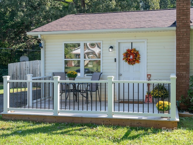 327 Downing St, Troutman, NC 28166 - doorway to property with roof with shingles, a wooden deck, a chimney, and outdoor dining area