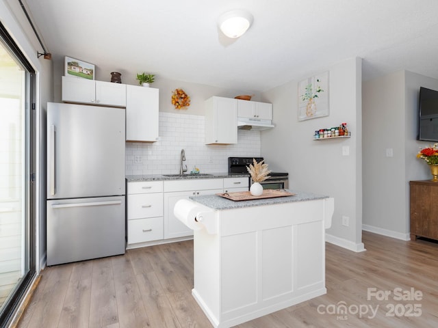 327 Downing St, Troutman, NC 28166 - kitchen with freestanding refrigerator, electric range oven, under cabinet range hood, light wood-style floors, and white cabinetry