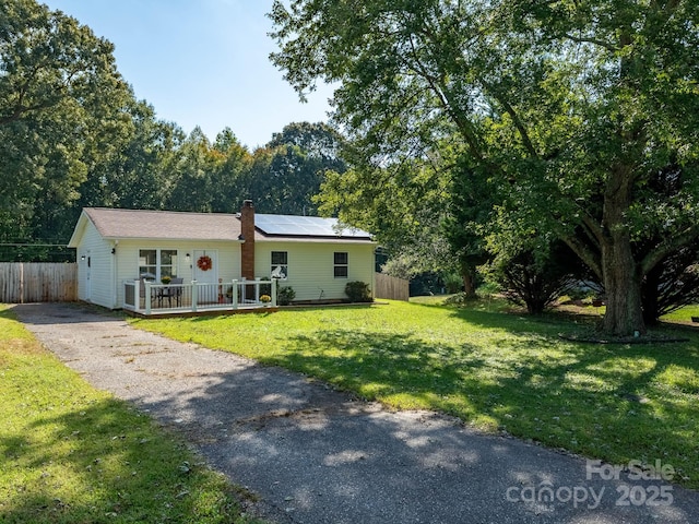 327 Downing St, Troutman, NC 28166 - ranch-style house with solar panels, driveway, and a chimney