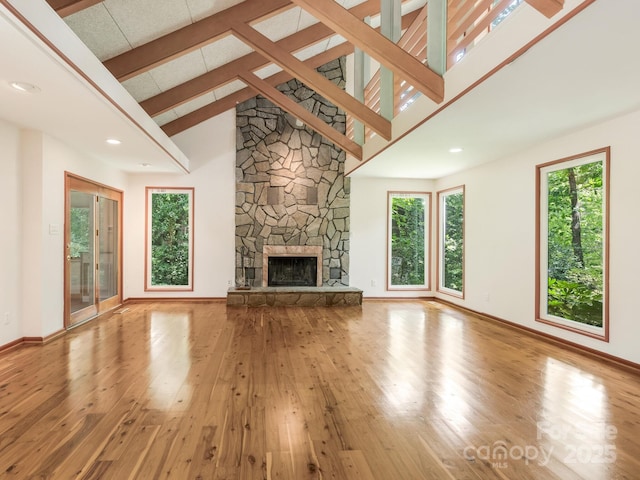 3310 Windbluff Dr, Charlotte, NC 28277 - unfurnished living room with plenty of natural light, hardwood / wood-style floors, a towering ceiling, a fireplace, and beamed ceiling