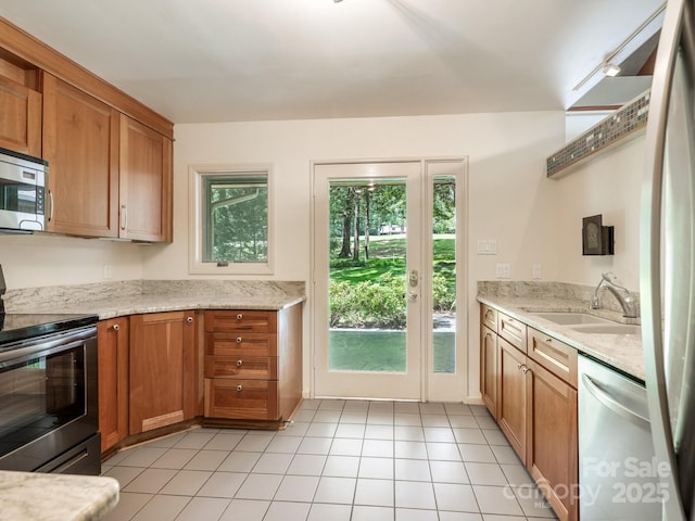 3310 Windbluff Dr, Charlotte, NC 28277 - kitchen with appliances with stainless steel finishes, brown cabinetry, and light tile patterned flooring