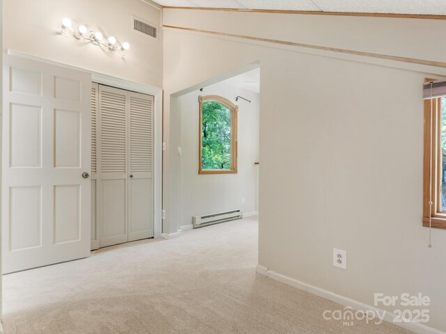 3310 Windbluff Dr, Charlotte, NC 28277 - unfurnished bedroom with baseboard heating, light colored carpet, a closet, and vaulted ceiling