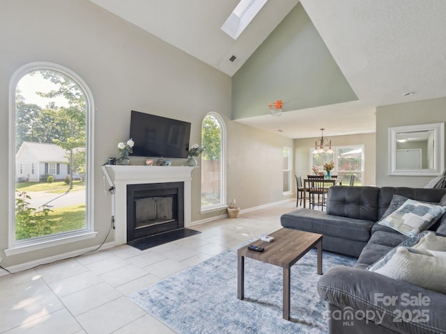 5701 Silver Eagle Dr, Charlotte, NC 28214 - tiled living area with plenty of natural light, a fireplace with flush hearth, a chandelier, a skylight, and high vaulted ceiling