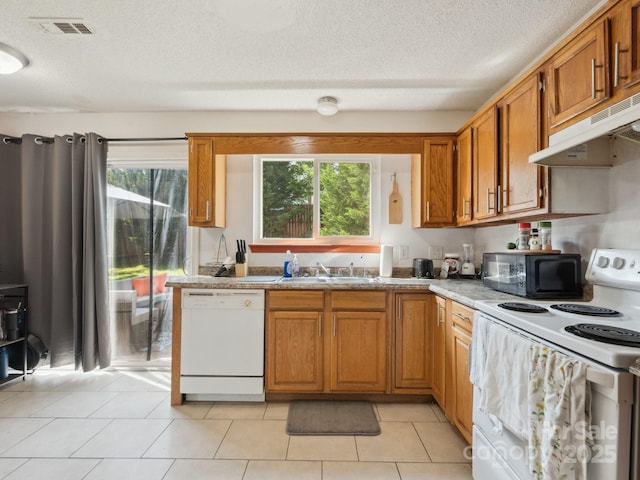5701 Silver Eagle Dr, Charlotte, NC 28214 - kitchen featuring white appliances, under cabinet range hood, brown cabinets, a textured ceiling, and plenty of natural light
