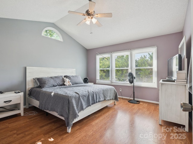 5701 Silver Eagle Dr, Charlotte, NC 28214 - bedroom featuring wood finished floors, vaulted ceiling, multiple windows, and ceiling fan