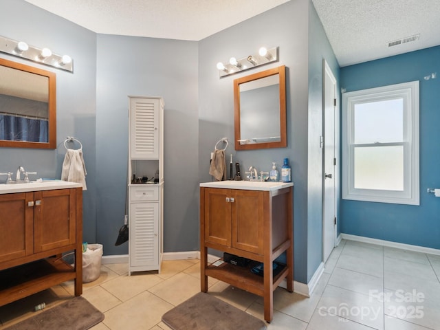5701 Silver Eagle Dr, Charlotte, NC 28214 - full bath featuring two vanities, tile patterned floors, and a textured ceiling