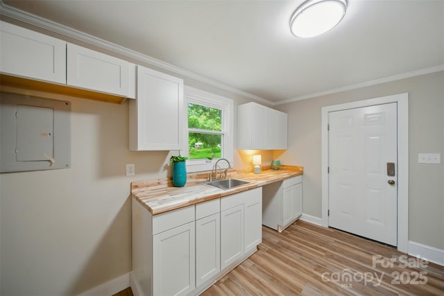 407 Cummings St, Rock Hill, SC 29730 - kitchen featuring electric panel, white cabinets, light wood-type flooring, ornamental molding, and butcher block counters