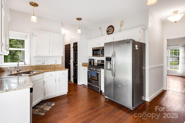 12 Eden Glen Rd, Black Mountain, NC 28711 - kitchen featuring appliances with stainless steel finishes, white cabinets, dark wood finished floors, light stone countertops, and decorative light fixtures