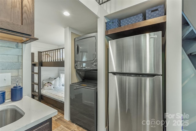 3095 Silversteen Rd, Lake Toxaway, NC 28747 - kitchen featuring stacked washer and clothes dryer, freestanding refrigerator, light wood-type flooring, and recessed lighting