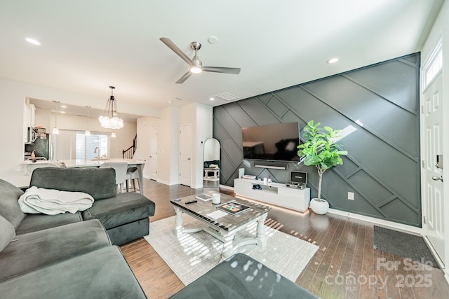 11546 Red Rust Ln, Charlotte, NC 28277 - living room featuring wood finished floors, a decorative wall, a ceiling fan, a chandelier, and an accent wall