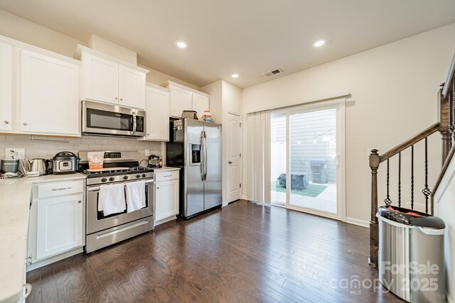 11546 Red Rust Ln, Charlotte, NC 28277 - kitchen with appliances with stainless steel finishes, dark wood-style flooring, white cabinetry, decorative backsplash, and recessed lighting