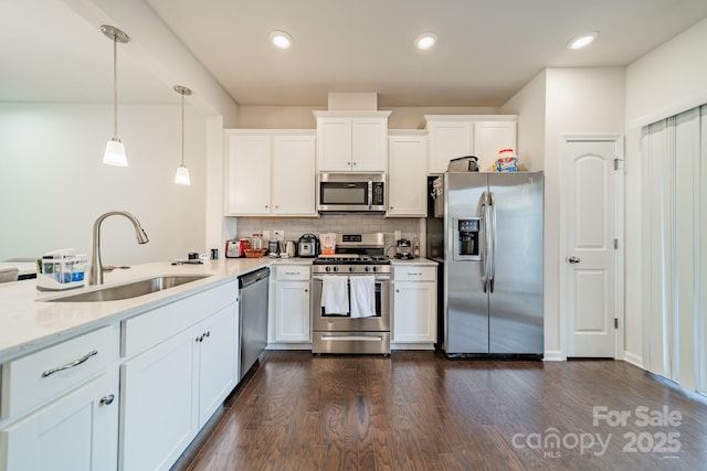11546 Red Rust Ln, Charlotte, NC 28277 - kitchen with stainless steel appliances, a peninsula, backsplash, white cabinets, and hanging light fixtures