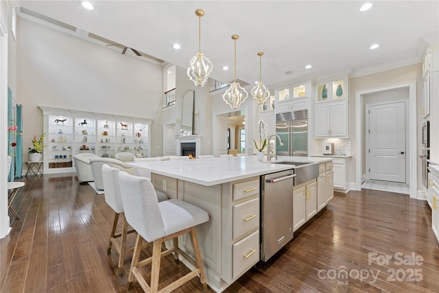 920 Terramore Dr, Waxhaw, NC 28173 - kitchen featuring appliances with stainless steel finishes, crown molding, glass insert cabinets, an island with sink, and white cabinetry