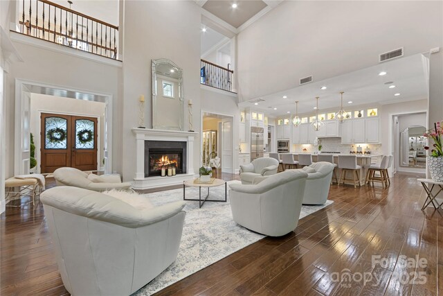 920 Terramore Dr, Waxhaw, NC 28173 - living area with a high ceiling, dark wood-style floors, a glass covered fireplace, crown molding, and plenty of natural light