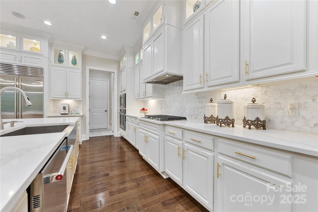 920 Terramore Dr, Waxhaw, NC 28173 - kitchen featuring appliances with stainless steel finishes, white cabinetry, crown molding, dark wood-style flooring, and light stone counters