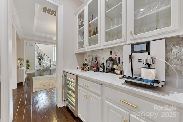 920 Terramore Dr, Waxhaw, NC 28173 - bar featuring wine cooler, crown molding, dark wood finished floors, backsplash, and stairs