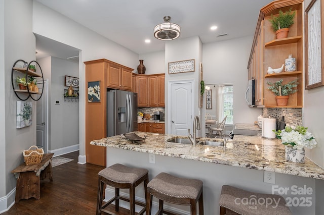 7988 Golf Course Dr N, Denver, NC 28037 - kitchen with a peninsula, appliances with stainless steel finishes, open shelves, tasteful backsplash, and light stone counters